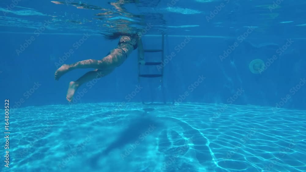 woman goes to the ladder and comes out of the water in swimming pool