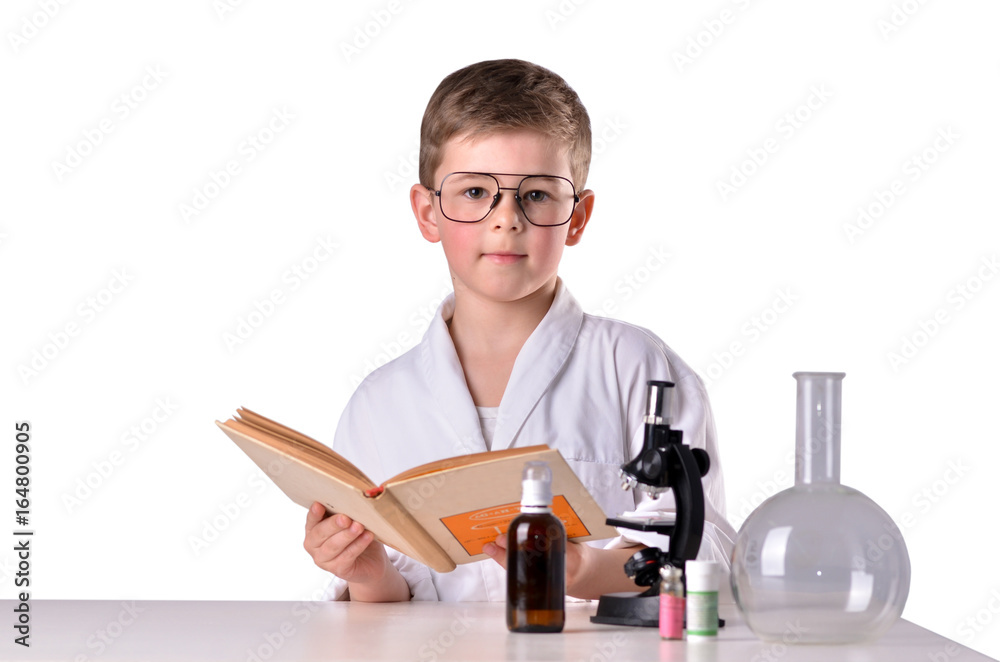 Scientist boy with open book at the desk in lab Scientist boy with open book at the desk in lab