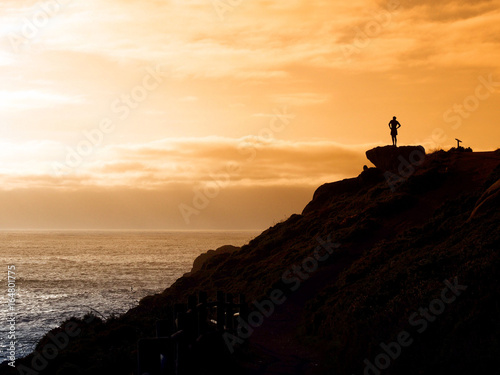 Man looking at the sea in the sunset