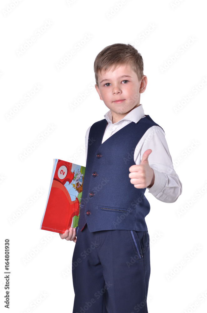 Schoolboy in blue suit with book in his hand thumbs up Schoolboy in blue suit with book in his hand thumbs up