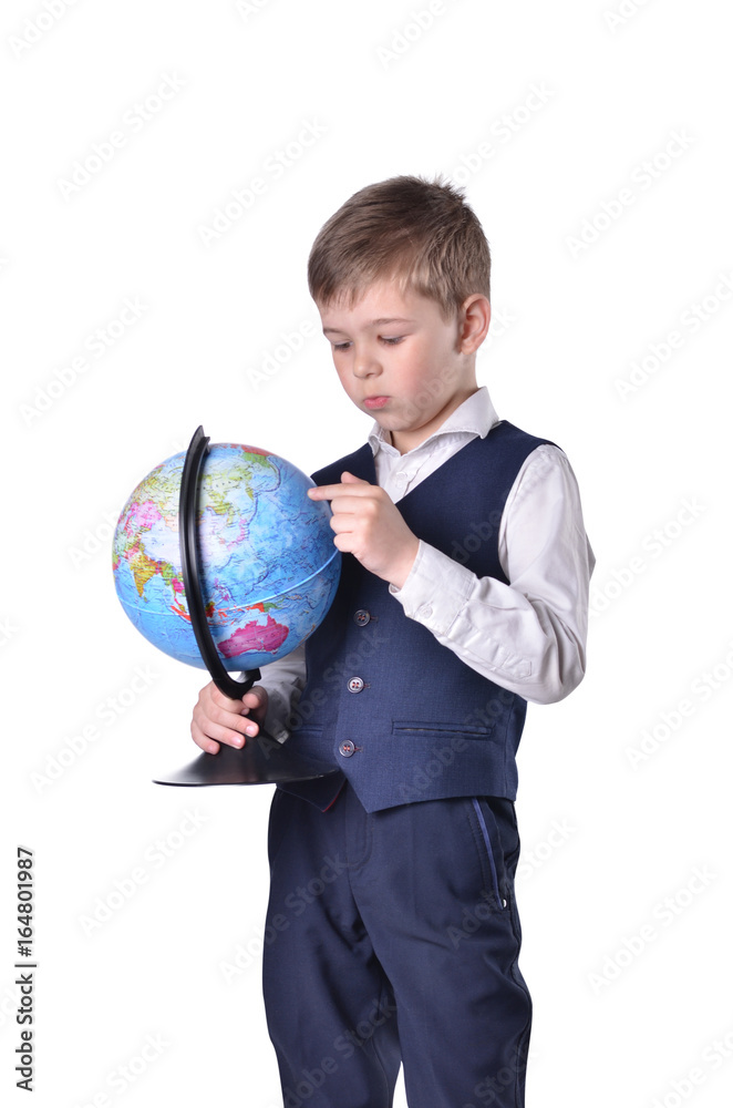 Standing schoolboy hold a globe of world and searching something on it Standing schoolboy hold a globe of world and searching something on it