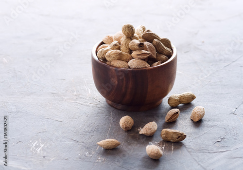 Wooden bowl with unpeeled nuts Nuts Almond peanuts Healthy snack Square photo