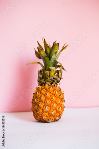 fresh pineapple on trend pink and white background, summer healthy veg food theme