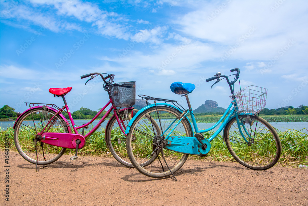 The bicycle stands on a village road at Thalkote lake near Sigiriya. Renting a bicycle and cycling around Sigiriya village is the most popular way among the tourists The bicycle stands on a village road at Thalkote lake near Sigiriya. Renting a bicycle and cycling around Sigiriya village is the most popular way among the tourists