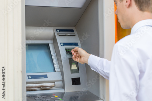 man hand insert credit card to atm