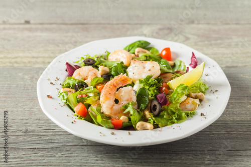 Shrimp salad with tomato, olives and cashew nuts.