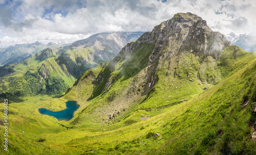 Mountain landscape in the alps with green pastures and mountain lake