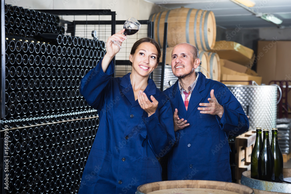 Two admiring winery workers in aging section of factory