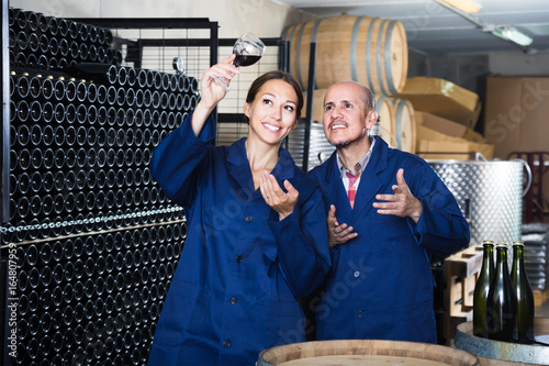 Two admiring winery workers in aging section of factory