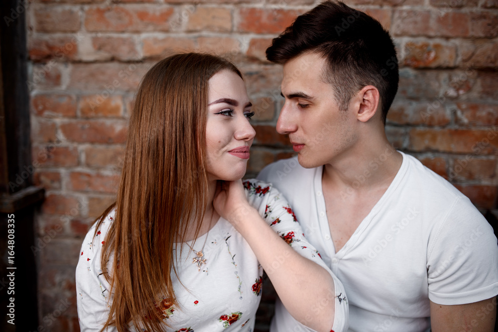 Naklejka premium Portrait of young modern couple in love, posing outdoors in city street