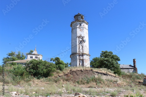 Old lighthouse on the beach in a summer sunny day