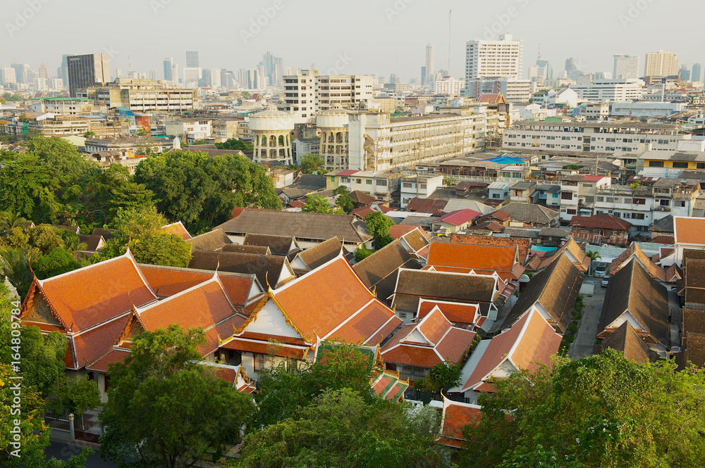View to the skyline of the old town with temples and skyscrapers at the background at sunrise from the Golden Mountain in Bangkok, Thailand.