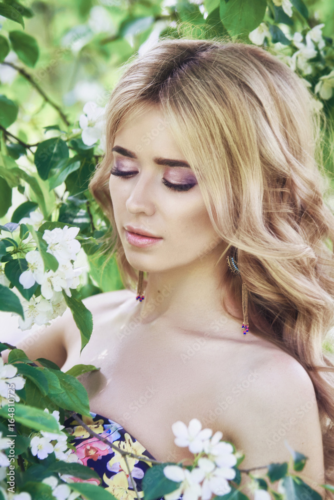 Outdoor fashion beautiful young woman surrounded by lilac flowers summer. Spring blossom lilac bush. Portrait of a girl blondes Outdoor fashion beautiful young woman surrounded by lilac flowers summer. Spring blossom lilac bush. Portrait of a girl blondes