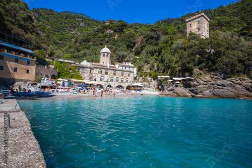 SAN FRUTTUSO DI CAMOGLI, ITALY, MAY, 4, 2016 - San Fruttuoso di Camogli, Ligurian coast, Genoa province, with its ancient Abbaey, the beach and tourists. photo