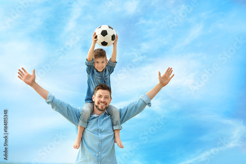 Dad and son with soccer ball outdoors photo