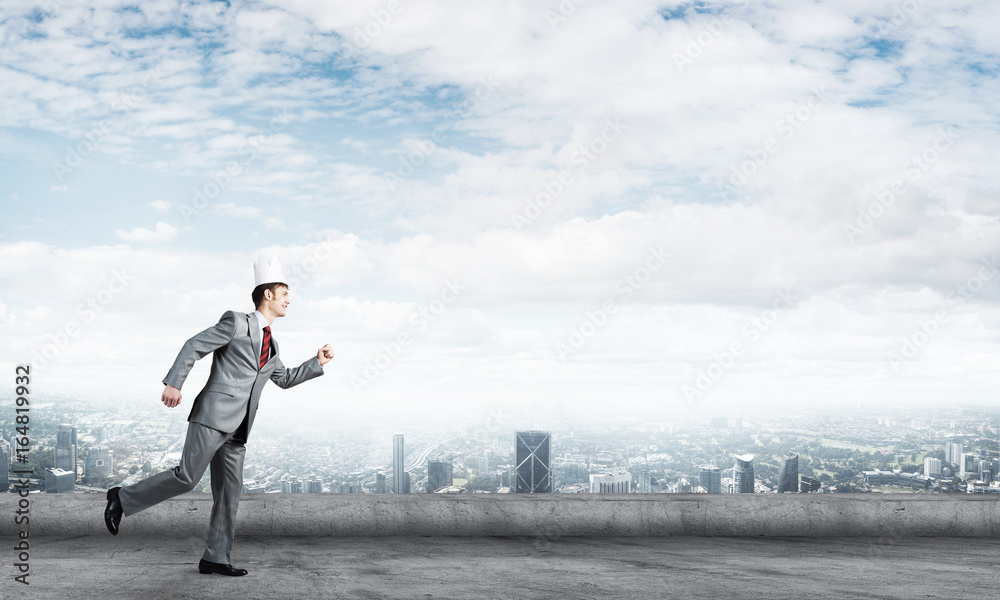 King businessman in elegant suit running on building roof and business center at background King businessman in elegant suit running on building roof and business center at background