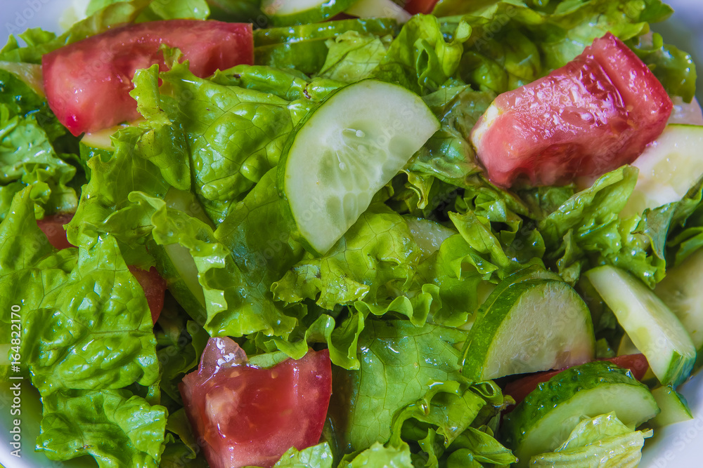 Fresh salad. Tomato, cucumber and greens in white bowl Fresh salad. Tomato, cucumber and greens in white bowl
