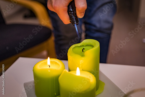 a man lighting three green candles