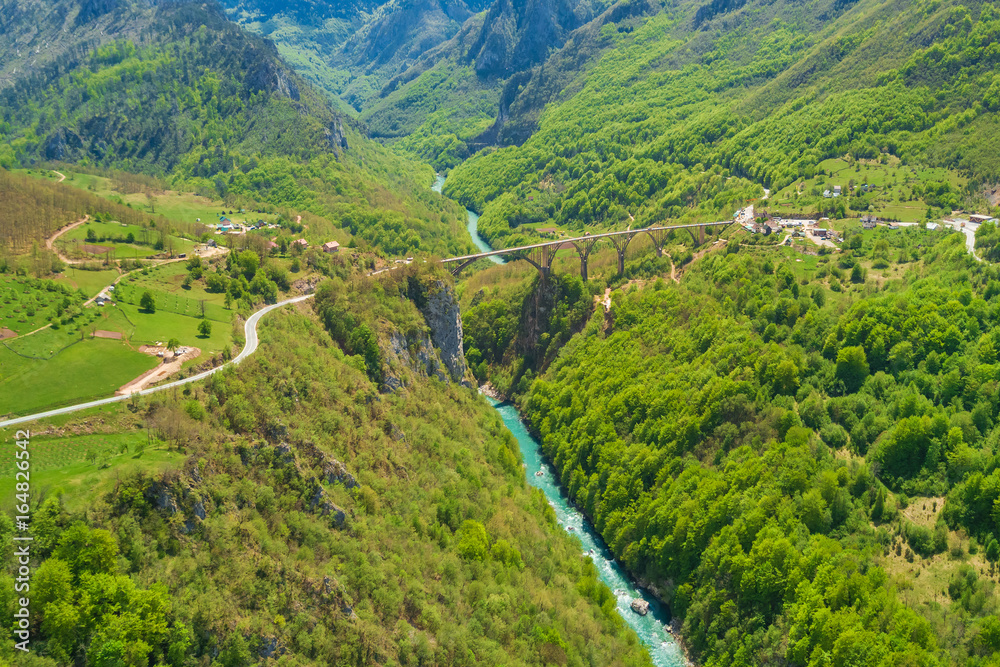 Road bridge over a river in the mountains, top view