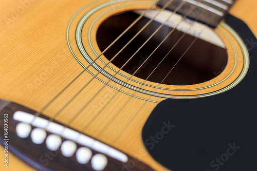 closeup acoustic guitar with soft-focus and over light in the background