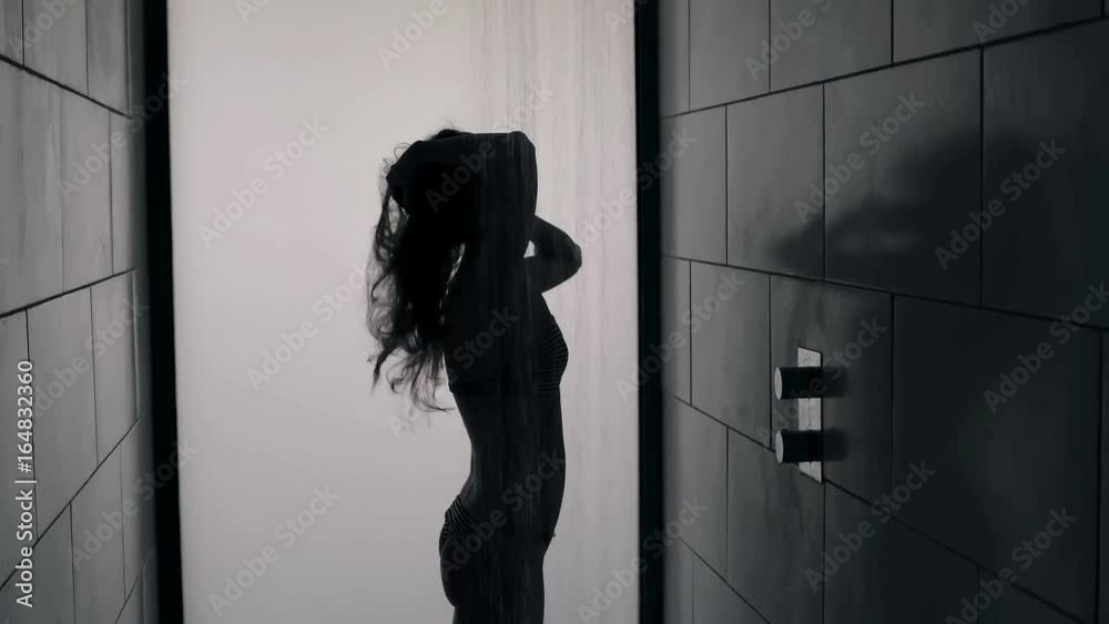 Silhouette of side view of woman taking a shower