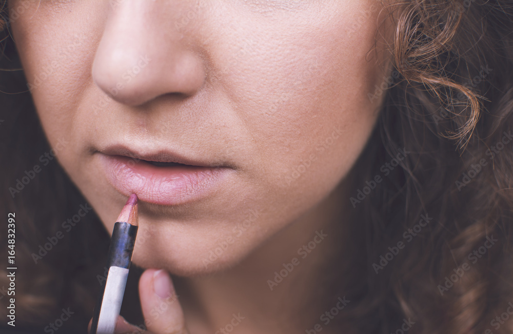 Close up of makeup artist applying lip liner on a woman's lips. Close-up of a woman's lips. Woman using lip liner. Close up of makeup artist applying lip liner on a woman's lips. Close-up of a woman's lips. Woman using lip liner.