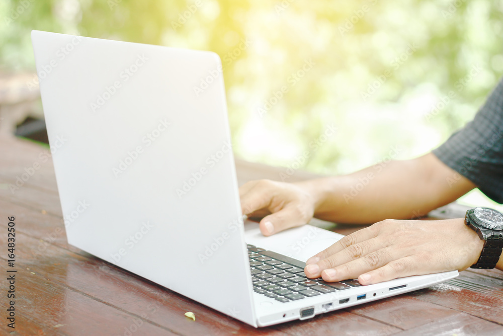 Stock photo :.Closeup image of a hands working and typing on laptop keyboard with blur nature background Stock photo :.Closeup image of a hands working and typing on laptop keyboard with blur nature background