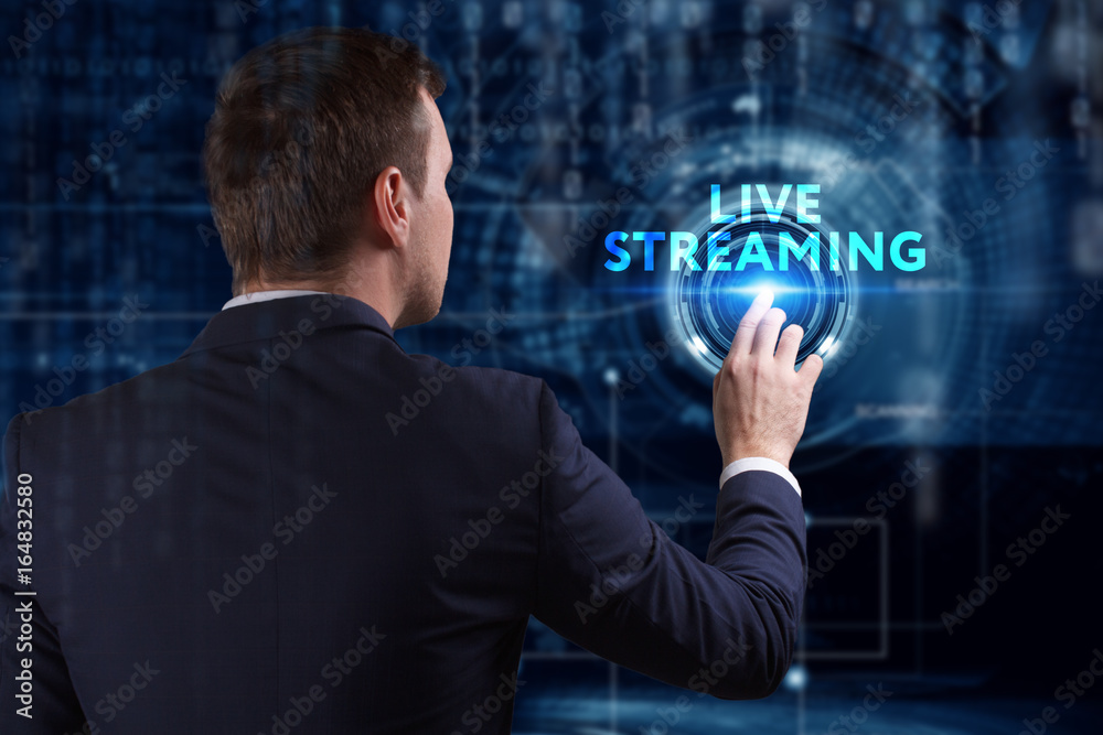 Business, Technology, Internet and network concept. Young businessman working on a virtual screen of the future and sees the inscription: Live streaming Business, Technology, Internet and network concept. Young businessman working on a virtual screen of the future and sees the inscription: Live streaming