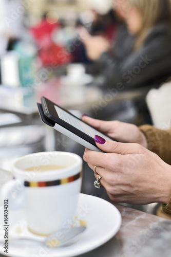 woman using a tablet in the terrace of a cafe