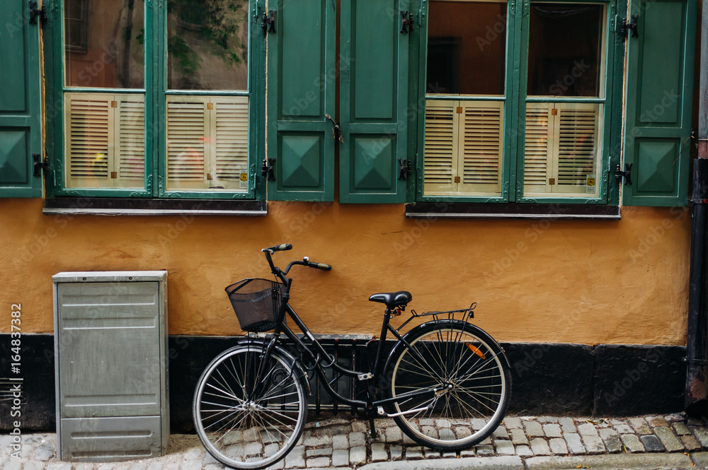 the bike on the background of yellow wall with green Windows