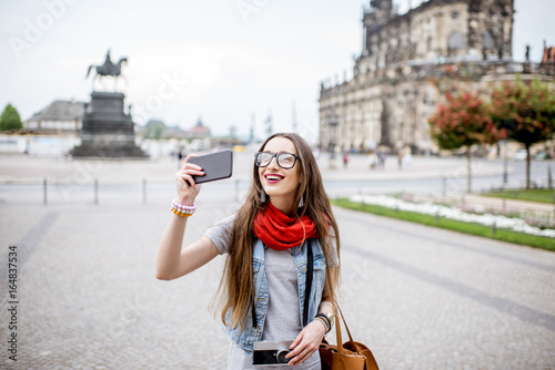 Young woman with photocamera walking on the Theaterplatz in Dresden, Germany