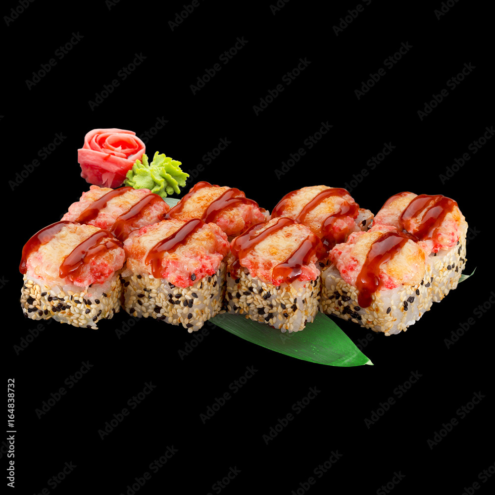 Japanese cuisine. Sushi roll with salmon and spice sauce over dark background. Japanese cuisine. Sushi roll with salmon and spice sauce over dark background.
