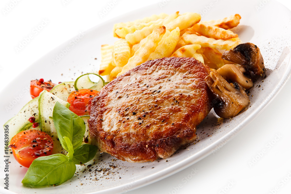 Grilled steak, French fries and vegetable salad on white background 