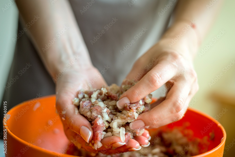 Women's hands mold something from minced meat. Horizontal frame