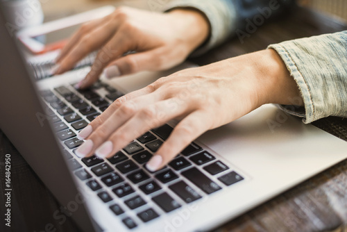 Morning business woman. Female hands working on a laptop, close-up. Horizontal frame
