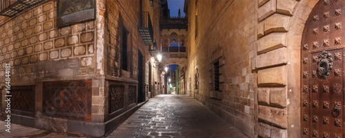 Photography Panorama of cobbled medieval Carrer del Bisbe street with Bridge of Sighs in Bar