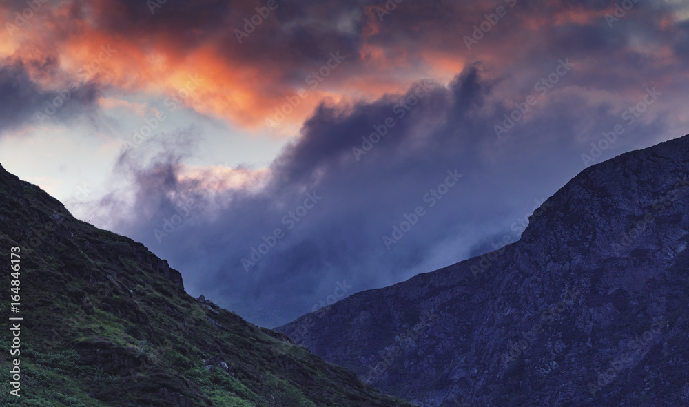 Colorful Dramatic Sunset Clouds over Nant Gwynant Valley Hills in Snowdonia UK