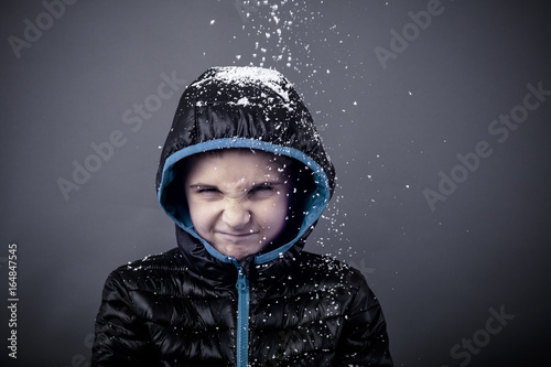 Spoiled adorable little boy in winter clothes