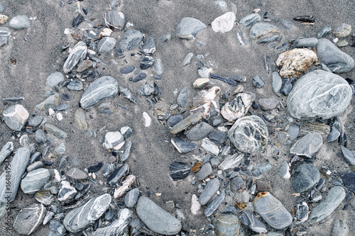 rocks and grey sand beach, background texture