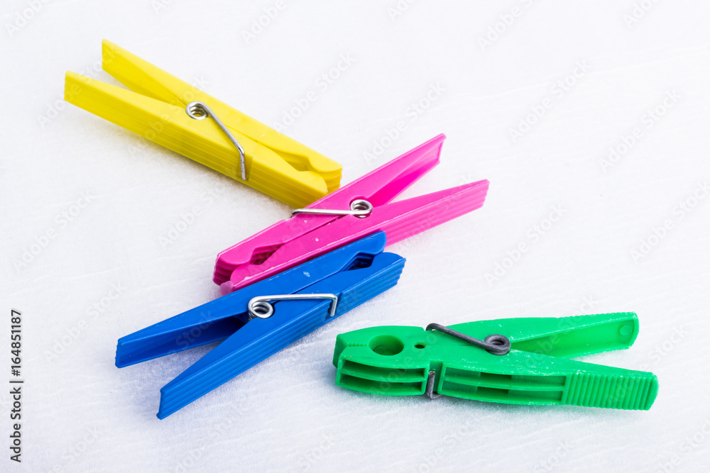 Four colorful clothespins on a white surface Four colorful clothespins on a white surface