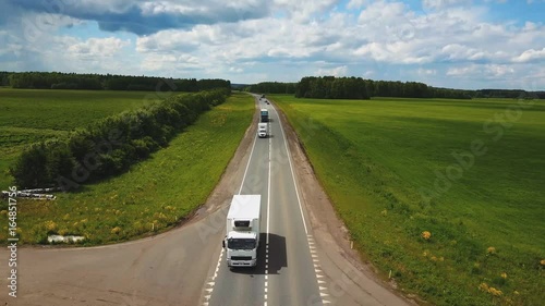 Beautiful landscape with a ride on the highway the trucks and a few cars at sunset. aerial view photo