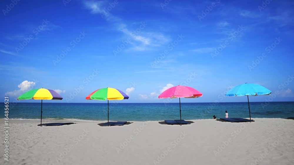 Tourists Wading with Colorful Umbrellas at Surin Beach, Phuket, Thailand Tourists Wading with Colorful Umbrellas at Surin Beach, Phuket, Thailand