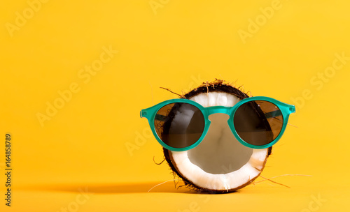 Fotografie, Tablou Fresh coconut wearing sunglasses on a bright yellow background