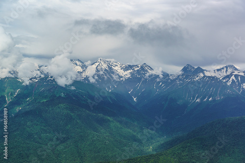 Landscape with snow-covered peaks of the Caucasus mountains and the deep gorge on a summer day © garmashevanatali