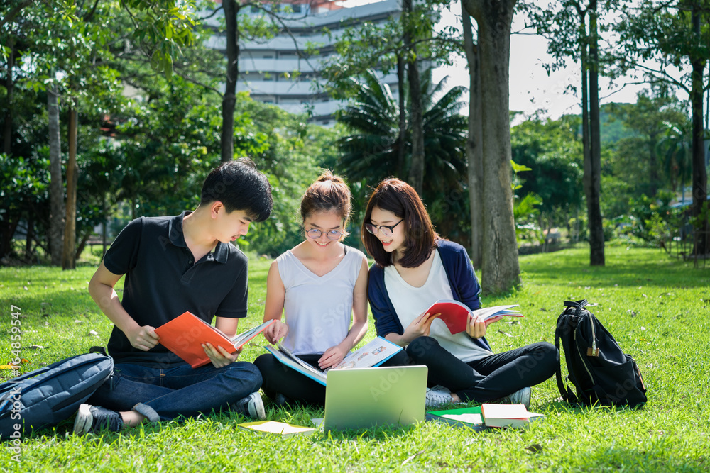 Young Student Asian Group Teenager with school folders on grass at university campus college Young Student Asian Group Teenager with school folders on grass at university campus college