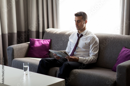 businessman reading newspaper at hotel room