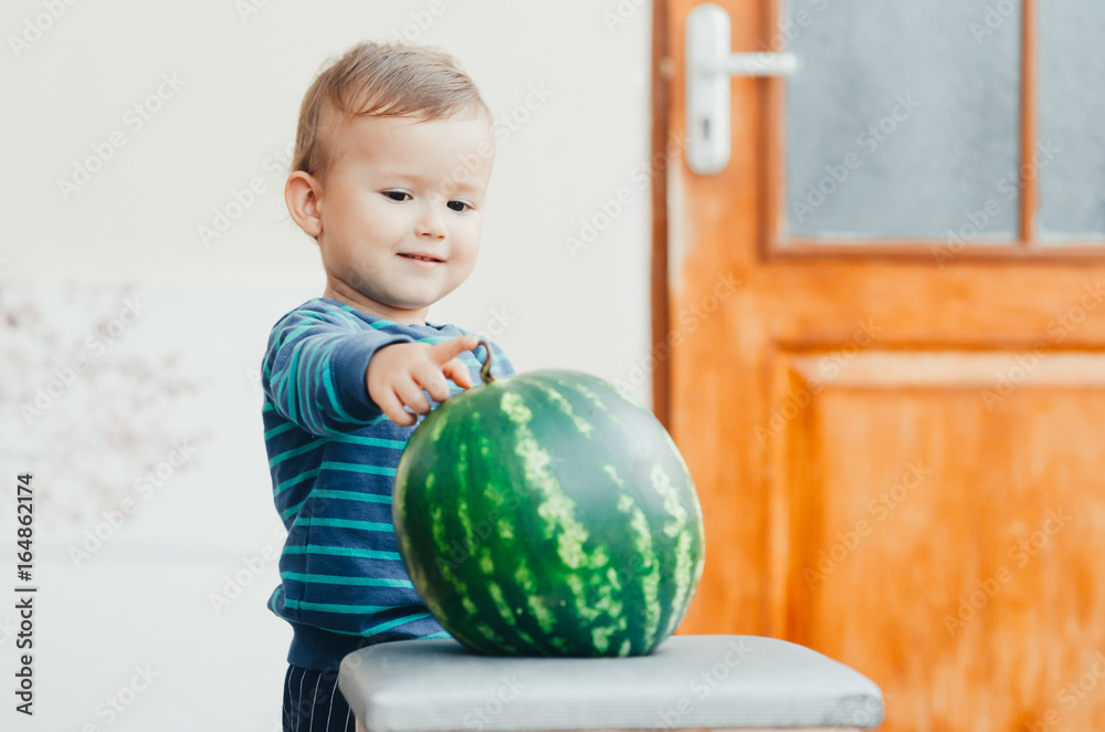 Fototapeta premium A little boy enjoys watermelon