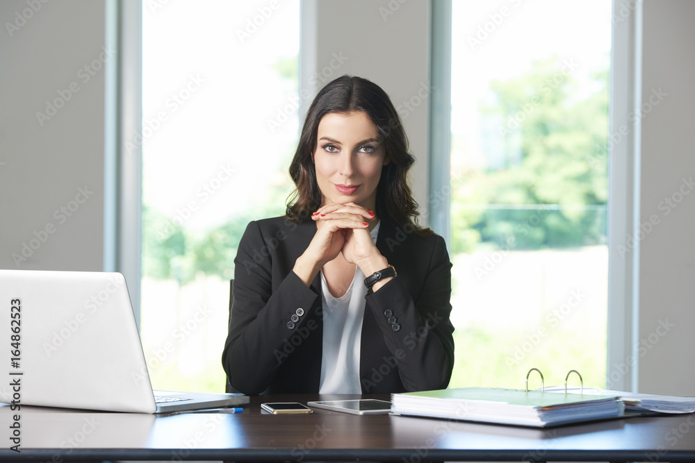 Confident young businesswoman portrait. Shot of a beautiful young professional woman looking thoughtful while sitting at office desk. Confident young businesswoman portrait. Shot of a beautiful young professional woman looking thoughtful while sitting at office desk.