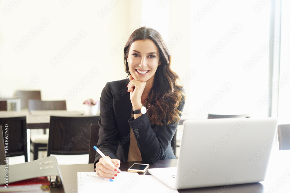 Confident young businesswoman portrait. Shot of a beautiful young professional woman looking thoughtful while sitting at office desk. Confident young businesswoman portrait. Shot of a beautiful young professional woman looking thoughtful while sitting at office desk.