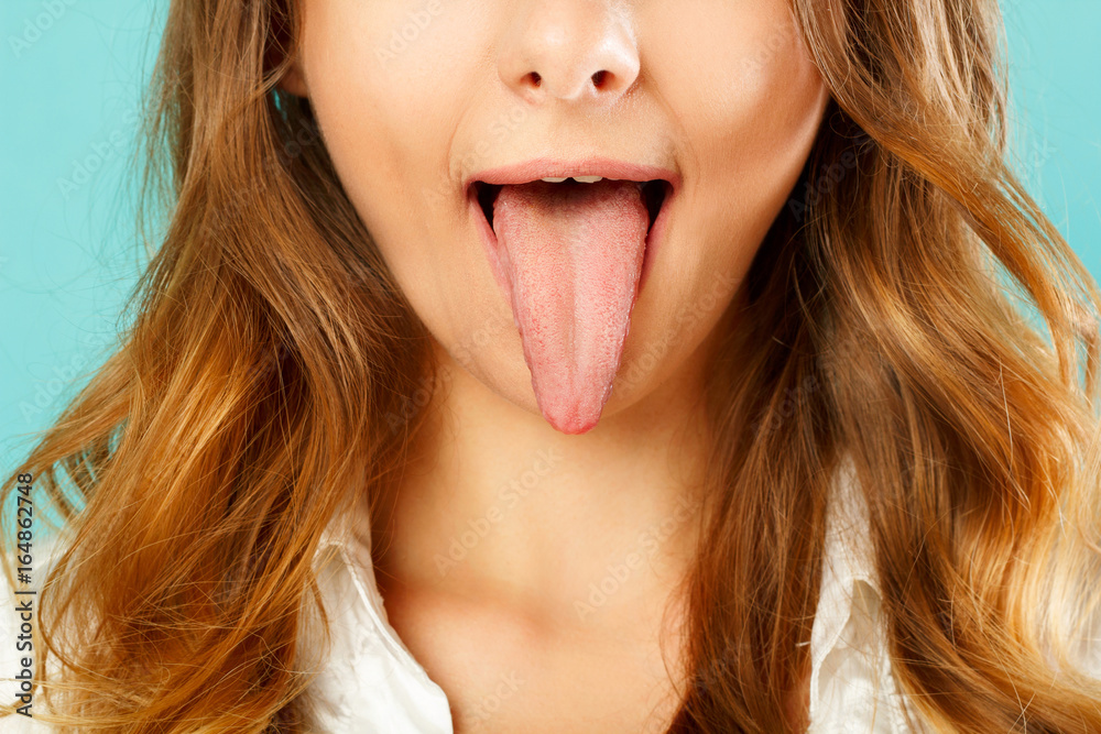 Fototapeta premium close up of healthy woman tongue over blue background